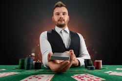 Male dealer at the casino at the table. Casino concept, gambling, poker, chips on the green casino table