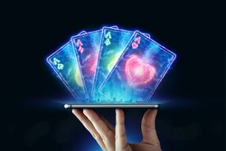 Creative background, online casino, in a man's hand a smartphone with playing cards, black-neon background. Internet gambling concept. Copy space