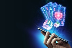 Creative background, online casino, in the male hand a smartphone with playing neon cards, neon background. Internet gambling concept. Copy space.