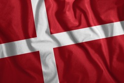 The Danish flag flutters in the wind. Colorful, national flag of Denmark. Patriotism, a patriotic symbol.