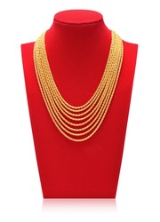 Gold necklace on necklace display stand. Red mannequin.
