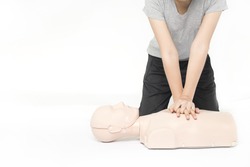 CPR training medical procedure,Demonstrating chest compressions on CPR doll in the class,White background