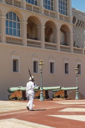 Guard on watch of Monaco royal palace with canons in background
