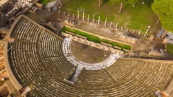 Aerial view on the Roman theatre of Ostia Antica, a large archaeological site, close to the modern town of Ostia. The ancient Roman Amphitheater is located in Rome, Italy.