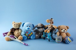 International day of persons with disabilities. Wheelchair with toys sign of different disabilities on blue background.