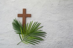 Palm sunday background. Cross and palm on grey background.