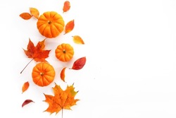 Pumpkins with fall leaves over white background. Top view.