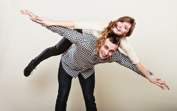 Love people and happiness concept. Smiling young couple having fun, man giving piggyback ride to woman