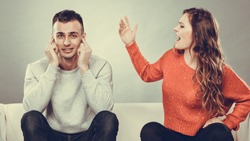 couple having argument - conflict, bad relationships. Angry fury woman screaming man closing his ears.