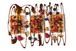 Belgian waffles with chocolate and berries on big white plate. Isolated.