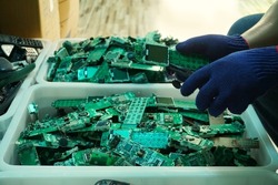 Telephone circuit board parts are being disassembled as electronic waste in the factory.
