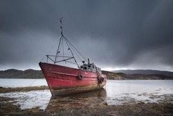 An old wooden hulled fishing boat, now abandonded and being left to rot