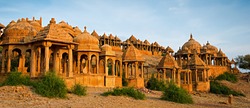 The royal cenotaphs of historic rulers, also known as Jaisalmer Chhatris, at Bada Bagh in Jaisalmer made of yellow sandstone at sunset