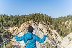 Woman crossing suspension bridge and conquering her fear