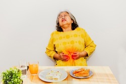 Senior woman had colic, severe abdominal pain during a snack : Elderly women have problems with excretion and complications that may be caused by cancer, kidney disease, enteritis, constipation.