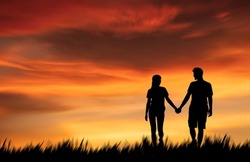 Silhouette couple walking hand in hand in love and bonding enjoying the sunset in the meadow at romantic twilight sunset sky background.