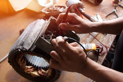 Electrical Equipment Inspection :  Electricians use a standard multimeter tool :  Close up of electric motor maintenance work.