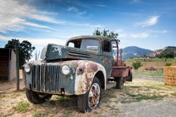 Rusted old truck near a farm