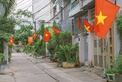 Flags along a small street in Hanoi. National Vietnamese flags set in houses narrow residential lane. Patriotism of citizens during the celebration of Vietnam National Day