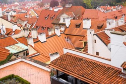Red roof of buildings in Prague in a cold cloudy fall weather. Old town of Prague with tiled roofs. Red roofs. Europe.