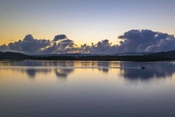 Sunrise waterscape with clouds and reflections at Woy Woy Waterfront on the Central Coast, NSW, Australia.