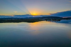 Aerial Sunrise over the water at Woy Woy Waterfront on the Central Coast, NSW, Australia.