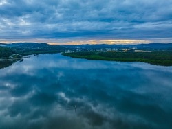Aerial sunrise waterscape with rain clouds at Woy Woy on the Central Coast, NSW, Australia.