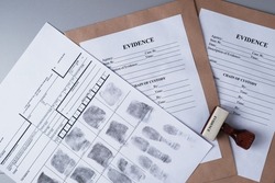 Fingerprint card and paper envelopes for packaging evidence on a gray background, forensic fingerprinting