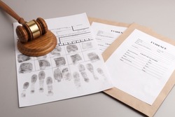Judges gavel, fingerprint cards and paper envelopes to pack evidence. Justice concept, forensic fingerprint analysis.
