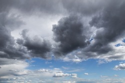 Beautiful storm sky, dark grey and white cumulus clouds on blue sky background texture, thunderstorm
