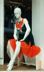 Mannequin wear stylish clothes and necklace showed on shopwindow of fashion shop