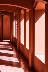 terracotta corridor with many arches in the hotel with hard contrasting shadows