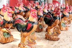 Tourist souvenir concept. Painted figurines, birds, rooster. National symbol. Bright clay figurines.