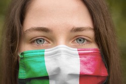 Portrait of a young girl in a medical mask with italian flag
