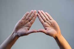 hand gesture, triangle shape, male doing triangle hand gesture on toned background, isolated. illuminati