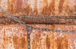 old rusty metal door closed with chain and padlock