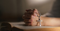 christian religion background christian woman hand on holy bible praying to god holding cross rosary selective focus at cross. concept of christian religious people faith and practise