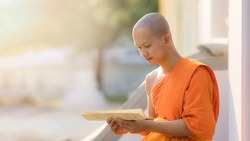 young buddhist monk at Buddhism temple reading Buddhist book to learn Buddha lessen