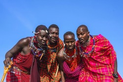 Maasai Mara man in traditional colorful clothing showing traditional Maasai jumping dance at Maasai Mara tribe village famous Safari travel destination near Maasai Mara National Reserve Kenya