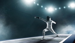 Professional fencer girl in fencing mask with rapier