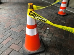 Yellow Caution Tape Wrapped Around Orange Cones - Construction and Traffic Signs