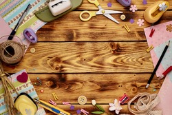 Tools for scrapbooking on the wooden background. Copy space in the middle.