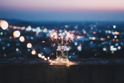 Sparklers in a glass jar that bokeh cities background.