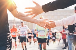 Marathon. Child's hand giving highfive. Concept of support at sport. 