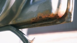 Car door with rust and metal corrosion. lose up corrosion, old rusty stain on hood car. Hard corrosion and rust on the body and doors of the silver car.