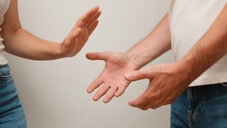 Young Couple with Communication Problems. Woman hand showing and saying stop against violence. Couple arguing and screaming at each other.