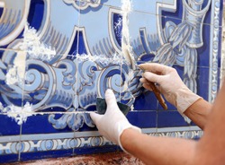 Restoration and conservation of antique tiles on the facade of a building. Professional working curator of restoration and conservation of antique tiles ceramic