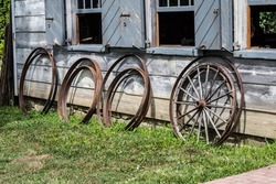 Wagon wheel parts against wheelwright shop. Parts waiting to be used to repair or replace broken wagon wheels