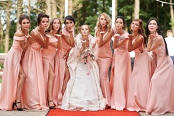 Wedding day. Beautiful bride and bridesmaids posing on the park on the wedding day. Bridesmaids dresses. Portrait of the bride and bridesmaids. wedding day after wedding ceremony