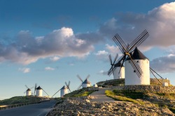 Group of ancient windmills in the town of Consuegra (Spain), on the route of the Don Quixote and Cervantes mills, at sunset.
